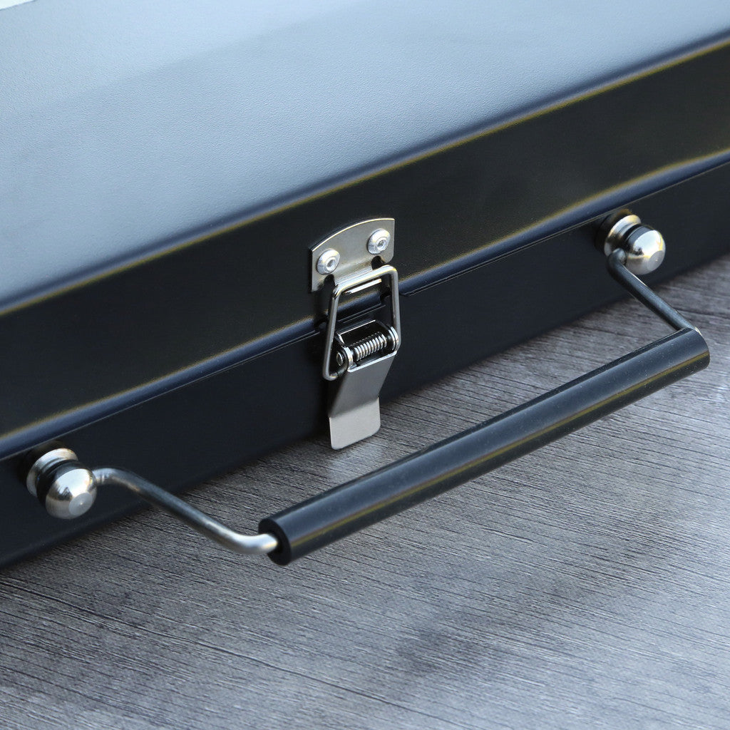 Black grill with a handle on a wooden surface