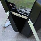 Black metal stand with adjustable legs on a gray surface