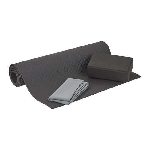 Gray yoga mat, block, and towel on a white background