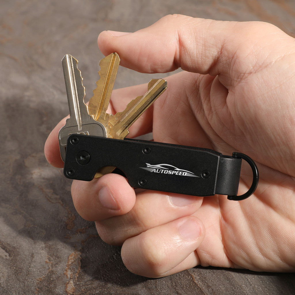 Hand holding a key organizer with keys on a wooden surface