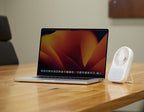 Laptop on a wooden table with a small white fan next to it