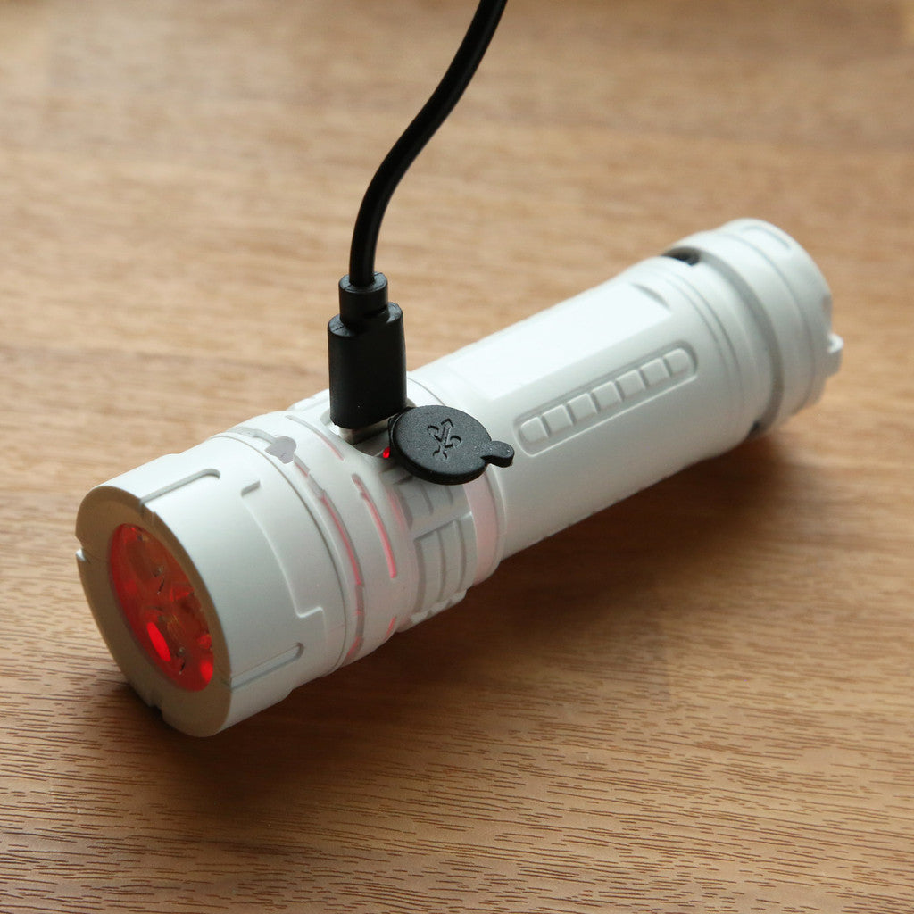 White reNew Lite Compact Rechargeable Flashlight shown charging