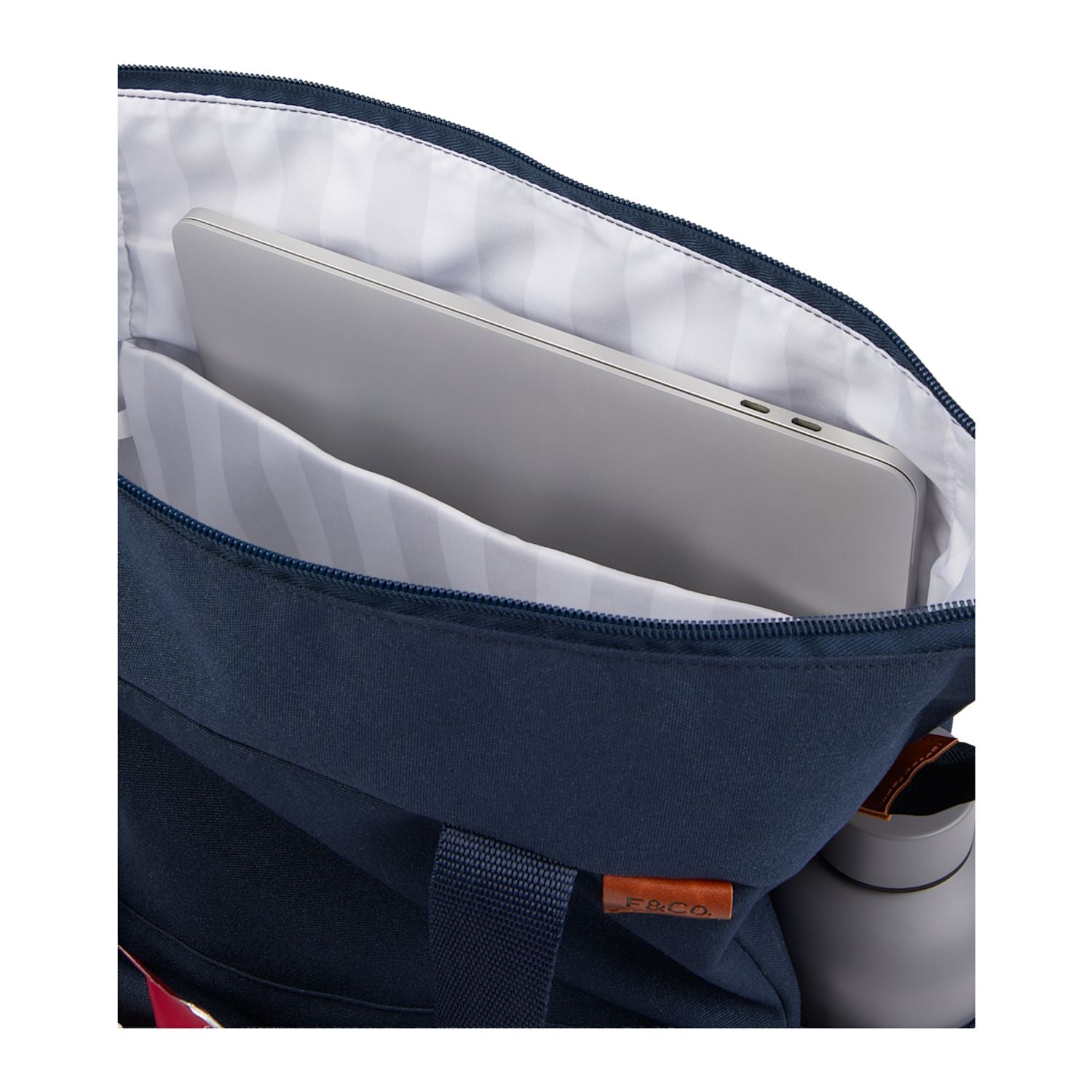 Navy blue backpack with a compartment holding a silver laptop on a white background
