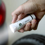 White reNew Lite Compact Rechargeable Flashlight shown turned on in a person's hand