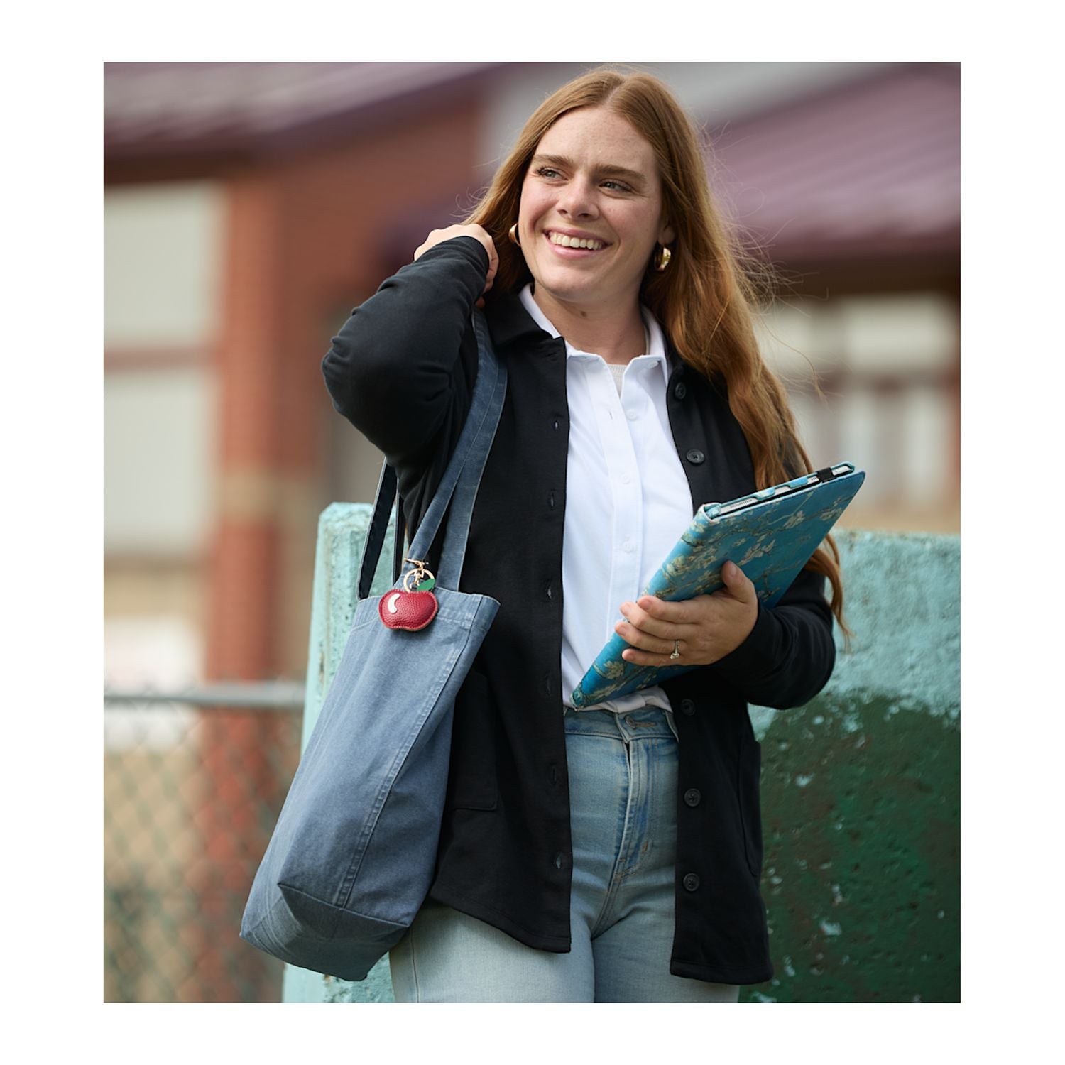 Apple Leather Keychain shown on a tote bag being carried by a lady