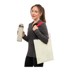 a person carrying a Nebraska 4oz Recycled Cotton Convention Tote 