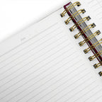 Open notebook with lined pages and a gold spiral binding on a white background