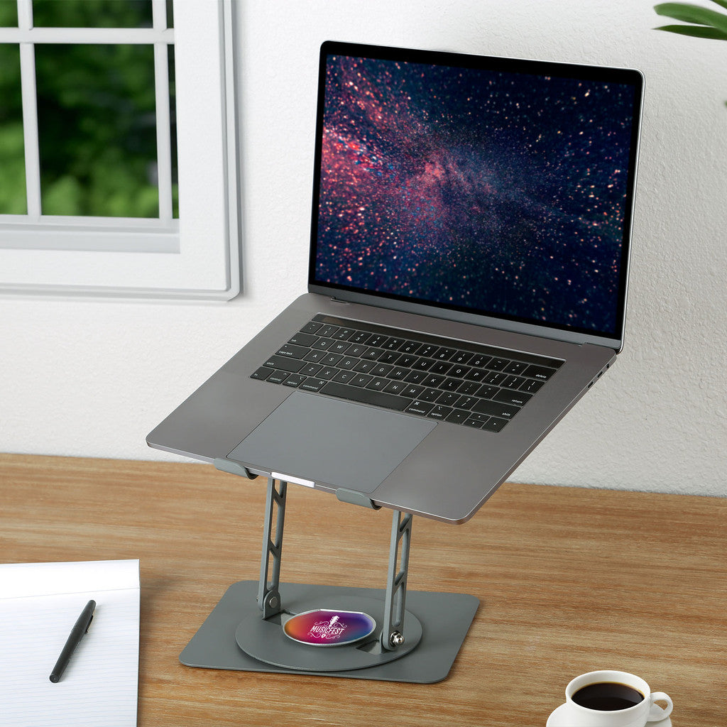 Laptop on a stand with a starry night wallpaper on a wooden desk.