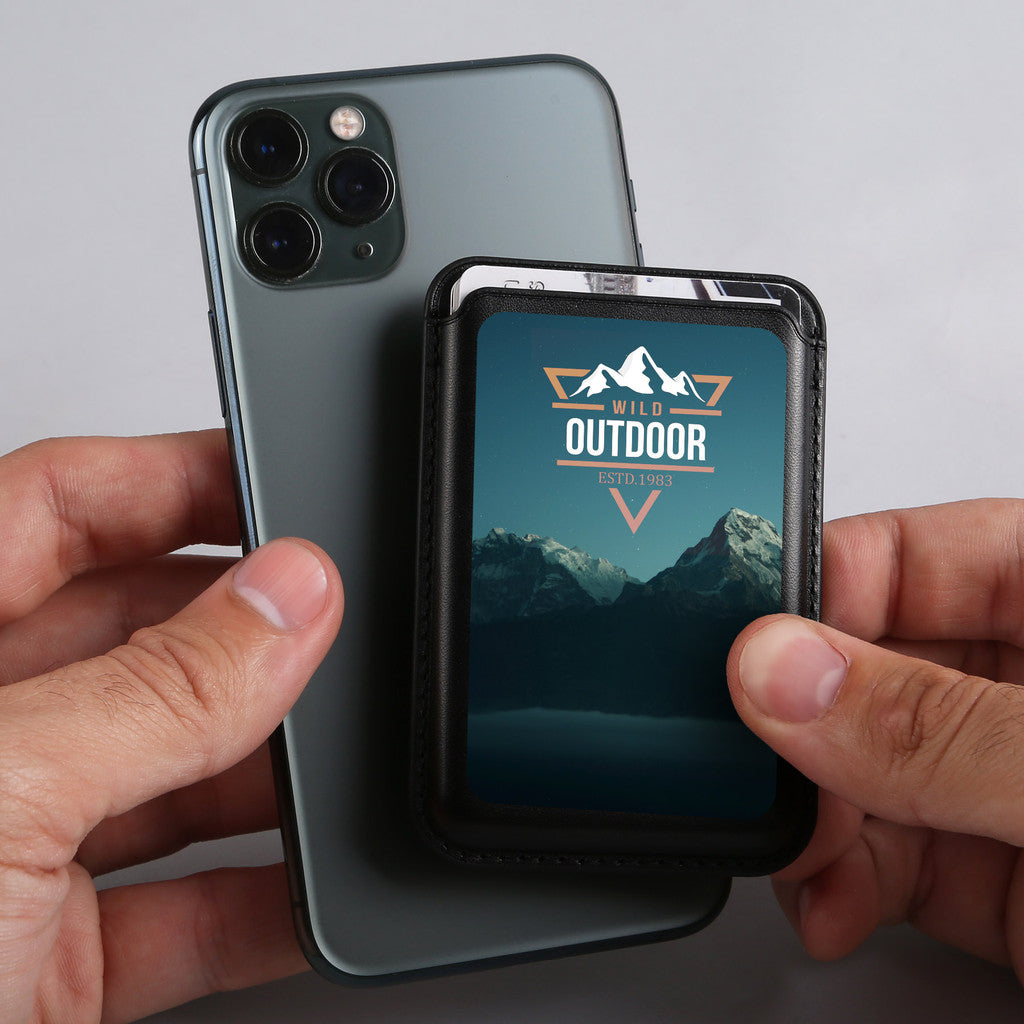 Person holding a phone with a protective case featuring a mountain design.