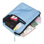 Blue travel organizer with various items including a hairbrush and cards on a white background