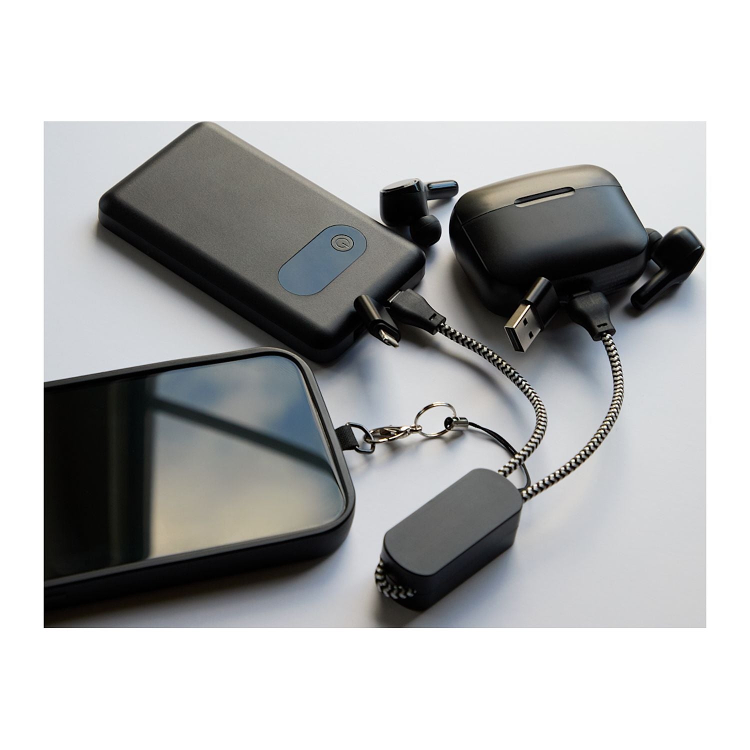 Set of electronic devices including a phone, power bank, earbuds, and charging cable on a light gray background.